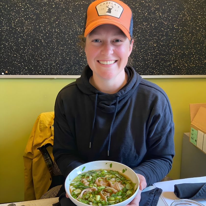 Leslie Svacina holding a bowl of goat wonton soup